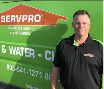 Jim standing in front of a green SERVPRO van