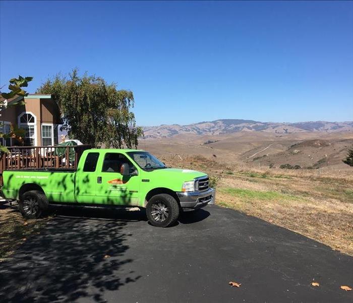 green pickup truck with a mountain landscape
