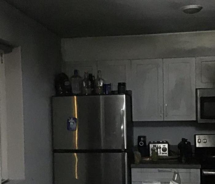 Fire damage in a kitchen. Fridge along the black soot
