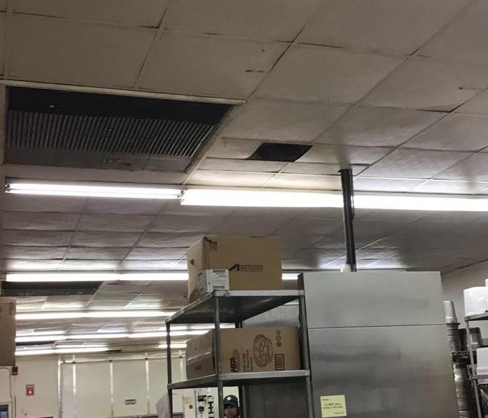 commercial kitchen with wet ceiling tiles with kitchen equipment around the floor
